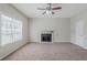 Bright living room featuring a fireplace, ceiling fan, and a large window at 4889 Hidden Creek Pl, Decatur, GA 30035