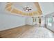 Large bedroom with tray ceiling, built in cabinet, and hardwood floors at 1425 Turtle Dove Ln, Lawrenceville, GA 30043