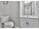 Clean half bathroom with toilet, sink, mirror, and white vanity at 1930 Huntcliff Dr, Lawrenceville, GA 30043