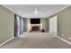 Living room with a fireplace, large windows, neutral color scheme and modern ceiling fan at 1930 Huntcliff Dr, Lawrenceville, GA 30043