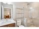 Modern bathroom featuring tiled shower with glass door, vanity with sink, and chrome shelving at 2172 Peach Se Ln, Smyrna, GA 30080