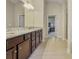 Bathroom boasts double vanity with stone countertops and tile flooring, with a view of the bedroom at 3204 Ivy Farm Path, Buford, GA 30519
