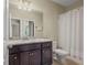Bathroom with granite vanity, dark wood cabinets, and large mirror complemented by neutral paint at 3204 Ivy Farm Path, Buford, GA 30519