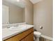 Clean half-bathroom featuring a single sink vanity with a large mirror, toilet and tile flooring at 418 Whisper Wood Way, Locust Grove, GA 30248