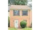 Charming brick townhouse featuring a white door with a decorative wreath and blue shutters at 3800 Travis Trce, Decatur, GA 30032