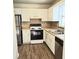 Bright kitchen featuring white cabinets, stainless steel appliances, and wood-look flooring at 3800 Travis Trce, Decatur, GA 30032
