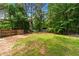 Large, grassy backyard with a shed and privacy fence, surrounded by mature trees at 466 Victoria Rd, Woodstock, GA 30189