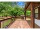 Inviting deck with wood flooring overlooks the backyard and lush greenery, creating a serene outdoor retreat at 466 Victoria Rd, Woodstock, GA 30189
