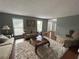 Spacious living room boasts hardwood floors, large windows, and comfortable seating arrangements at 525 Dunagan Dr, Lawrenceville, GA 30045