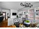 Spacious dining room with a glass table, unique chandelier, and a view into the living area at 653 N Highland Ne Ave # 3, Atlanta, GA 30306