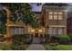 Inviting two-story brick home with manicured landscaping, mature trees, and covered entryway at dusk at 653 N Highland Ne Ave # 3, Atlanta, GA 30306