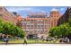 An exterior view shows the Ponce City Market brick building complex and surrounding green spaces at 653 N Highland Ne Ave # 3, Atlanta, GA 30306