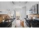 Galley kitchen featuring white cabinets, black granite countertops, and stainless steel appliances at 653 N Highland Ne Ave # 3, Atlanta, GA 30306