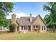 Inviting home exterior featuring a well-maintained lawn, mature trees, and double doors leading to the backyard at 221 The Esplanade Se Way, Loganville, GA 30052