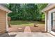 Backyard view featuring a brick walkway leading to a bird bath surrounded by green trees at 221 The Esplanade Se Way, Loganville, GA 30052