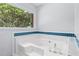 Close up of large white soaking tub with tiled backsplash in bathroom at 221 The Esplanade Se Way, Loganville, GA 30052