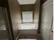 Bright bathroom featuring a tiled backsplash soaking tub and a privacy window at 288 Blue Pointe Ct, Suwanee, GA 30024