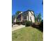 Attractive multi-story brick townhome with manicured lawn, driveway, and mature trees in the background at 288 Blue Pointe Ct, Suwanee, GA 30024