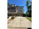 Attractive multi-story brick townhome with manicured lawn, driveway, and mature trees in the background at 288 Blue Pointe Ct, Suwanee, GA 30024