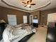 Spacious carpeted main bedroom with a ceiling fan, tv and ample natural light at 288 Blue Pointe Ct, Suwanee, GA 30024