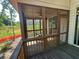 View of screened porch with chair, ceiling fan, and backyard view at 288 Blue Pointe Ct, Suwanee, GA 30024