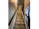 Carpeted staircase with iron railings, connecting multiple floors of the home at 288 Blue Pointe Ct, Suwanee, GA 30024