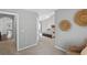 View from hallway into carpeted bedroom featuring ceiling fan, bed, and tasteful decorations at 4922 Carson Glen Ln, Acworth, GA 30101