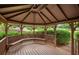 Interior view of a wooden gazebo with benches and an intricate roof design at 4922 Carson Glen Ln, Acworth, GA 30101