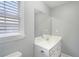 Powder room featuring a sleek vanity, mirror, and natural light, designed for convenience and style at 1010 Capella Creek Way, Grayson, GA 30017