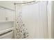 Bathroom featuring storage cabinet and shower with bathtub behind floral curtain at 1010 Capella Creek Way, Grayson, GA 30017
