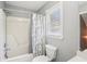 Well-lit bathroom showcasing a shower-tub combo with modern fixtures and a decorative shower curtain at 1010 Capella Creek Way, Grayson, GA 30017