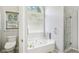 Bright bathroom featuring a soaking tub, glass shower, and modern fixtures at 1010 Capella Creek Way, Grayson, GA 30017