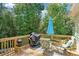 Wooden deck with outdoor furniture, a grill, and an umbrella, perfect for outdoor dining and entertaining at 1010 Capella Creek Way, Grayson, GA 30017