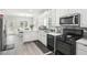 Open concept kitchen featuring stainless appliances, white cabinets, tile backsplash, and eat-in breakfast area at 1010 Capella Creek Way, Grayson, GA 30017