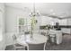 Bright eat-in kitchen featuring white cabinets, granite counters, gray backsplash, and stainless steel appliances at 1010 Capella Creek Way, Grayson, GA 30017