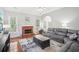 Bright living room with hardwood floors, brick fireplace, ceiling fan, and a gray sectional sofa at 1010 Capella Creek Way, Grayson, GA 30017