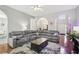 Cozy living room with hardwood floors, arched doorways, ceiling fan and a large sectional sofa at 1010 Capella Creek Way, Grayson, GA 30017