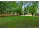 Large, well-maintained backyard with lush grass, mature trees, a wooden fence, and a hammock area for relaxation at 1634 Glenwood Se Ave, Atlanta, GA 30316