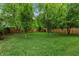 Expansive backyard featuring lush green grass, mature trees, and a wooden fence creating a private and inviting outdoor space at 1634 Glenwood Se Ave, Atlanta, GA 30316