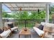 Relaxing covered patio featuring comfortable white seating, a wooden table, and a serene view of the lush surroundings at 1634 Glenwood Se Ave, Atlanta, GA 30316
