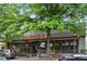Charming restaurant exterior with large windows, inviting lighting, and outdoor seating, nestled under lush trees at 1634 Glenwood Se Ave, Atlanta, GA 30316
