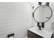 Stylish bathroom with a round mirror, dark wood vanity, and modern fixtures at 1712 Shirley Sw St, Atlanta, GA 30310