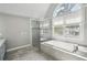 Luxurious bathroom featuring a soaking tub under a window and a separate glass shower at 1712 Shirley Sw St, Atlanta, GA 30310