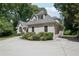View of the home with an attached garage, complemented by mature landscaping and a well-maintained lawn at 1712 Shirley Sw St, Atlanta, GA 30310