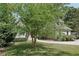 View of the home partially hidden by a large tree in the front yard, with mature landscaping at 1712 Shirley Sw St, Atlanta, GA 30310
