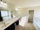 Bathroom featuring a large countertop, dual sinks, soaking tub and tiled floor at 2378 Misty Ivy Ct, Buford, GA 30519