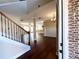 Inviting foyer with dark wood floors, staircase with wooden handrail, and views of the open-concept living space at 2378 Misty Ivy Ct, Buford, GA 30519