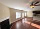 Sun-drenched living area with hardwood floors, a fireplace, and an adjacent kitchen area at 2378 Misty Ivy Ct, Buford, GA 30519