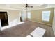 Main bedroom with two bright windows, carpet, and a view of the en-suite bathroom at 2378 Misty Ivy Ct, Buford, GA 30519