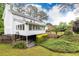 White house exterior with spacious backyard, mature trees, and a wooden deck at 2730 Burtz Dr, Marietta, GA 30068